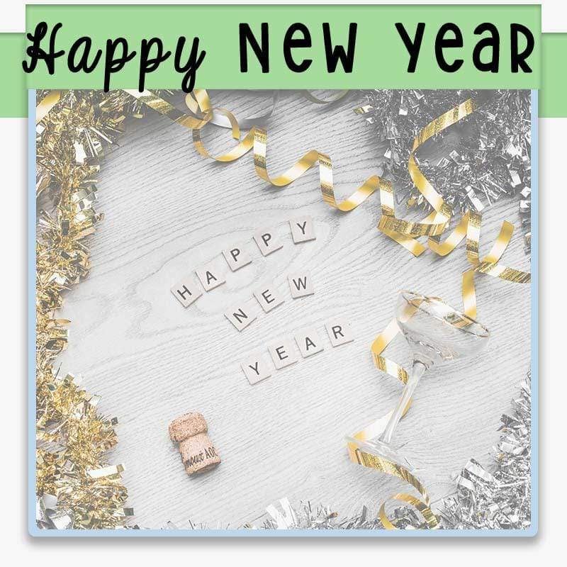 flat lay with silver and gold ribbon and scrabble tiles spelling happy new year